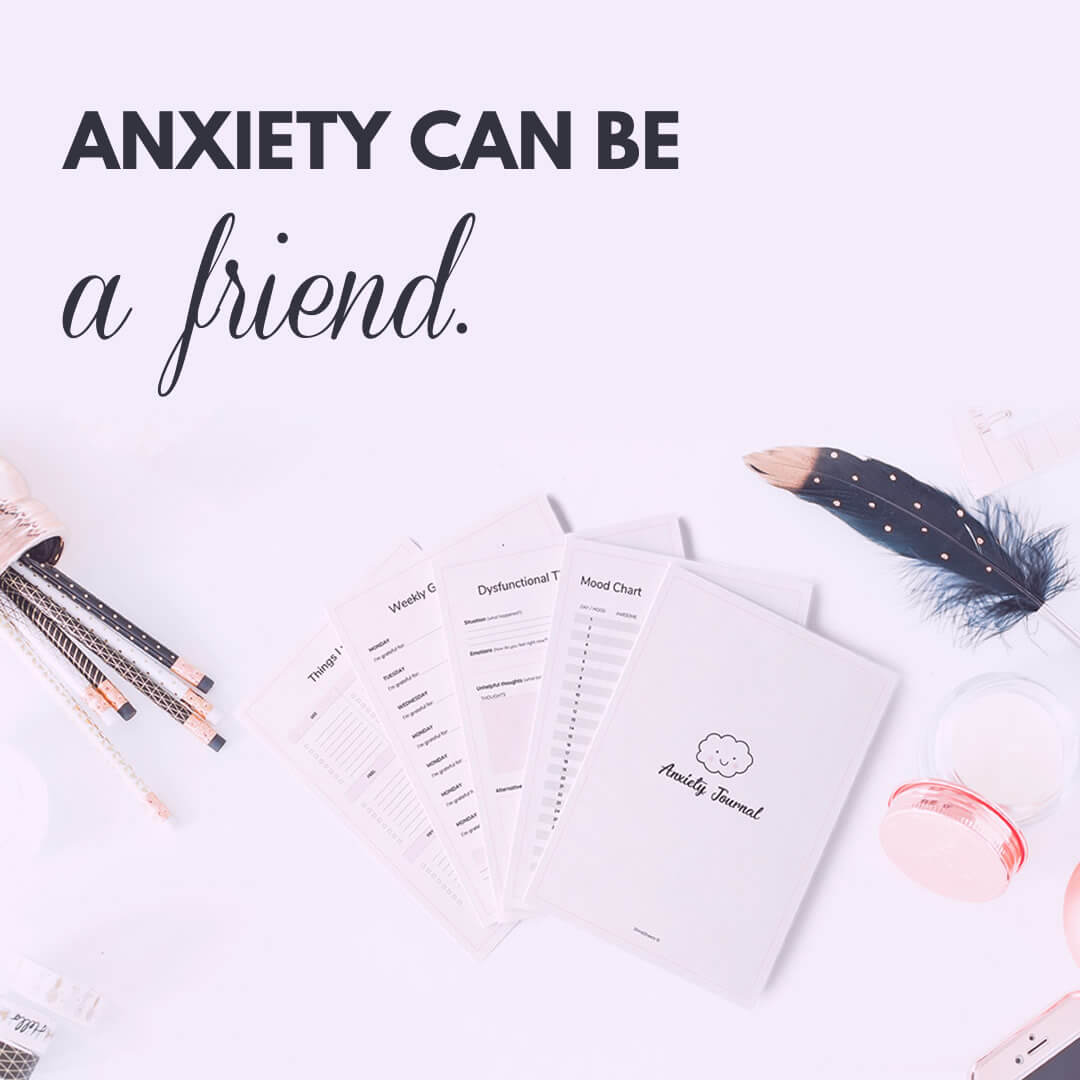 printed anxiety journal, pens and decorations on the table