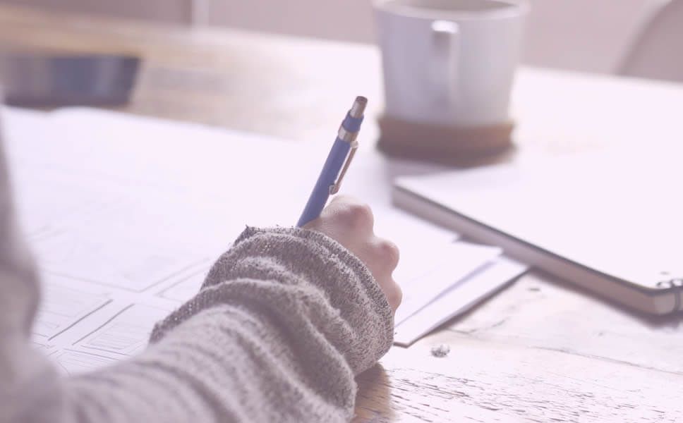 A girl with a comfy sweater writes in her anxiety journal