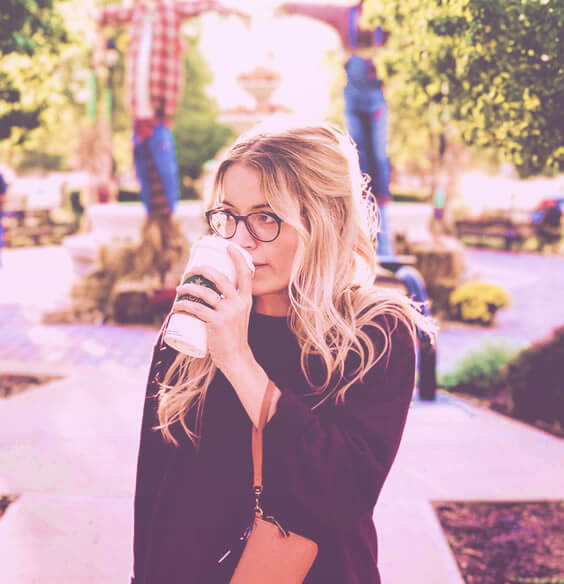 blonde woman with glasses walking in a park