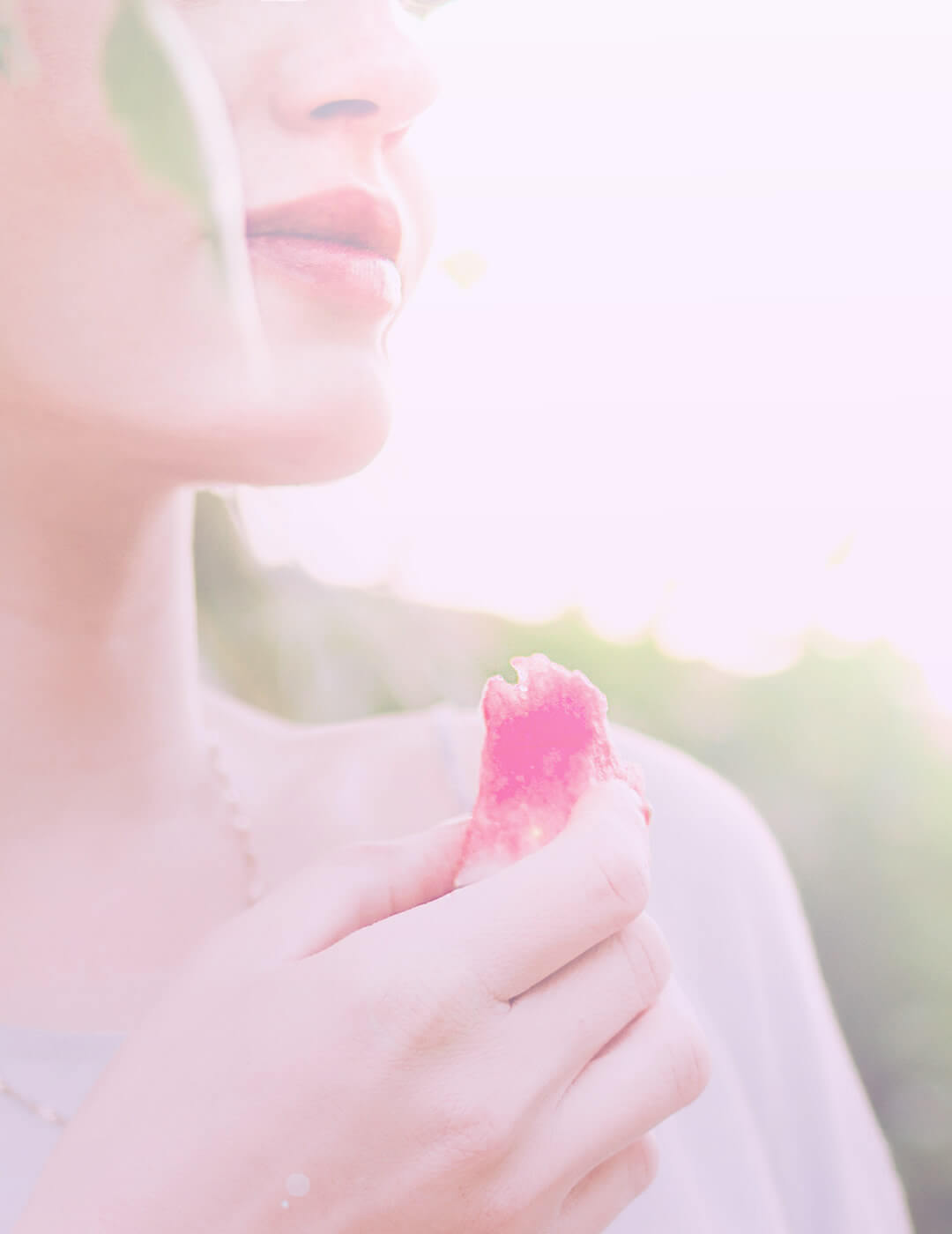 a woman eatign a piece of watermelon