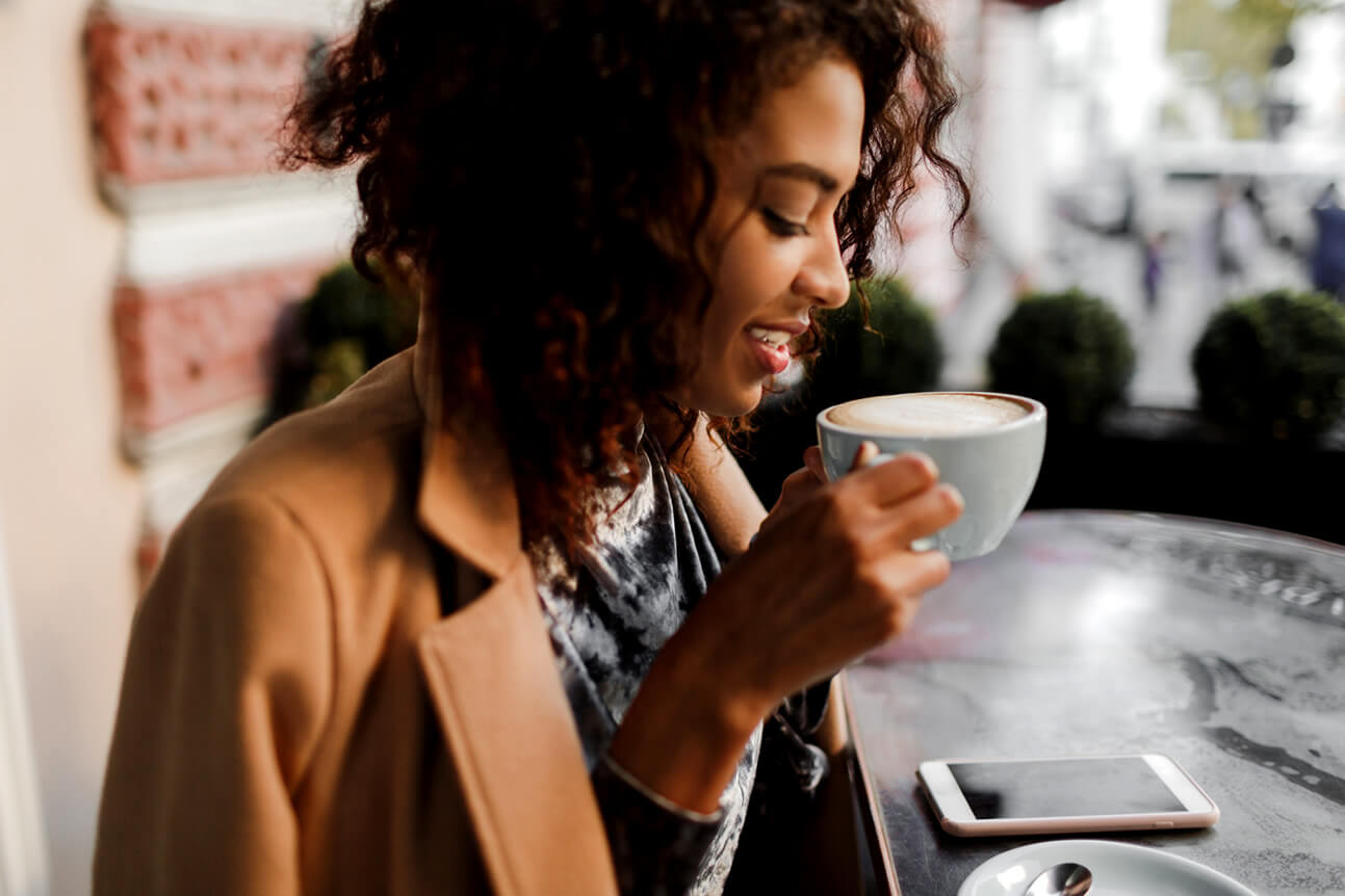 pretty black woman drinking morning coffee as part of her good habits routine