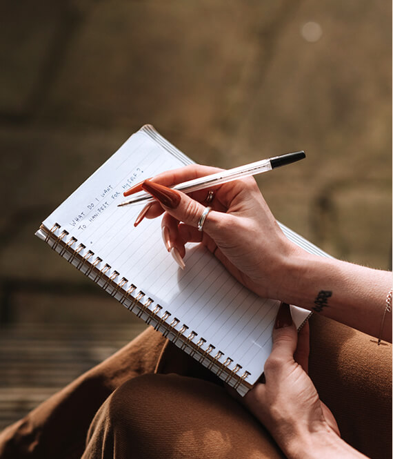 woman writing down goals to start achieving them