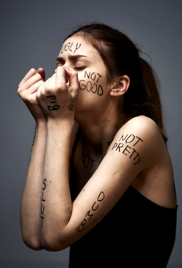 woman with negative self talk examples written on her body