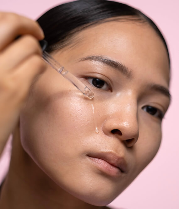 asian dermatologist showing how to layer skincare products on her own face