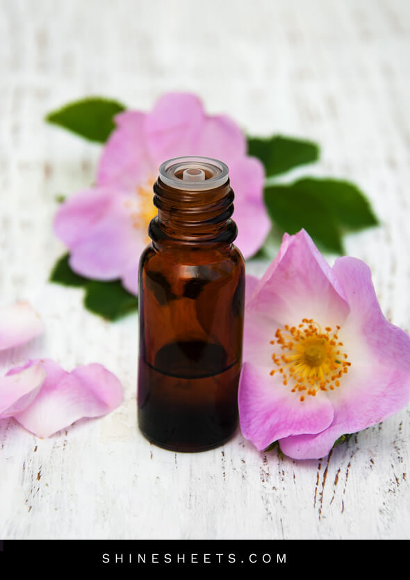 a small bottle of rosehip oil for face and rosehip flowers