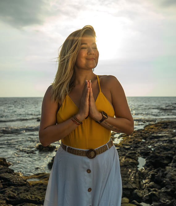 happy woman meditating on the beach for mental balance