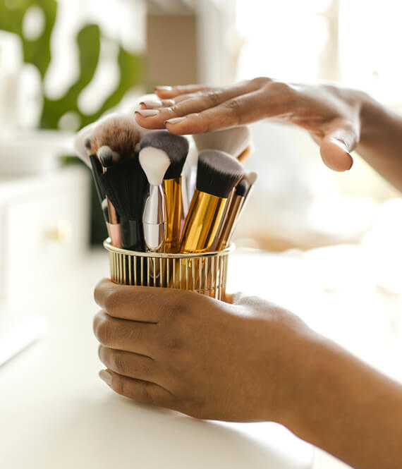 woman touching deep-cleaned makeup brushes
