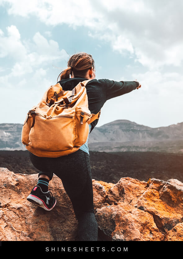 woman climbing a mountain as a symbol of living happier through adventure
