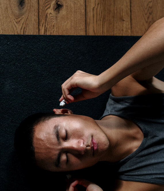 asian man putting in headphones to meditate