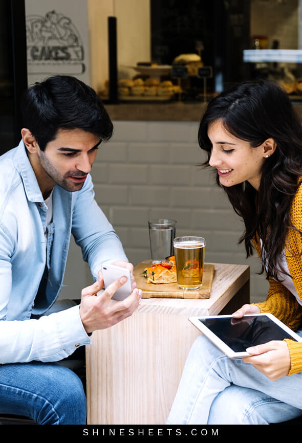 guy that has a crush on girl shows her interesting pictures on his phone