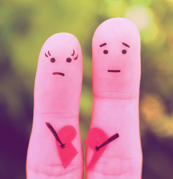 Two fingers painted like an unhappy couple holding a broken heart a symbolic picture of being unhappy in a relationship
