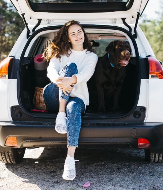woman and her dog sitting in an organized car trunk