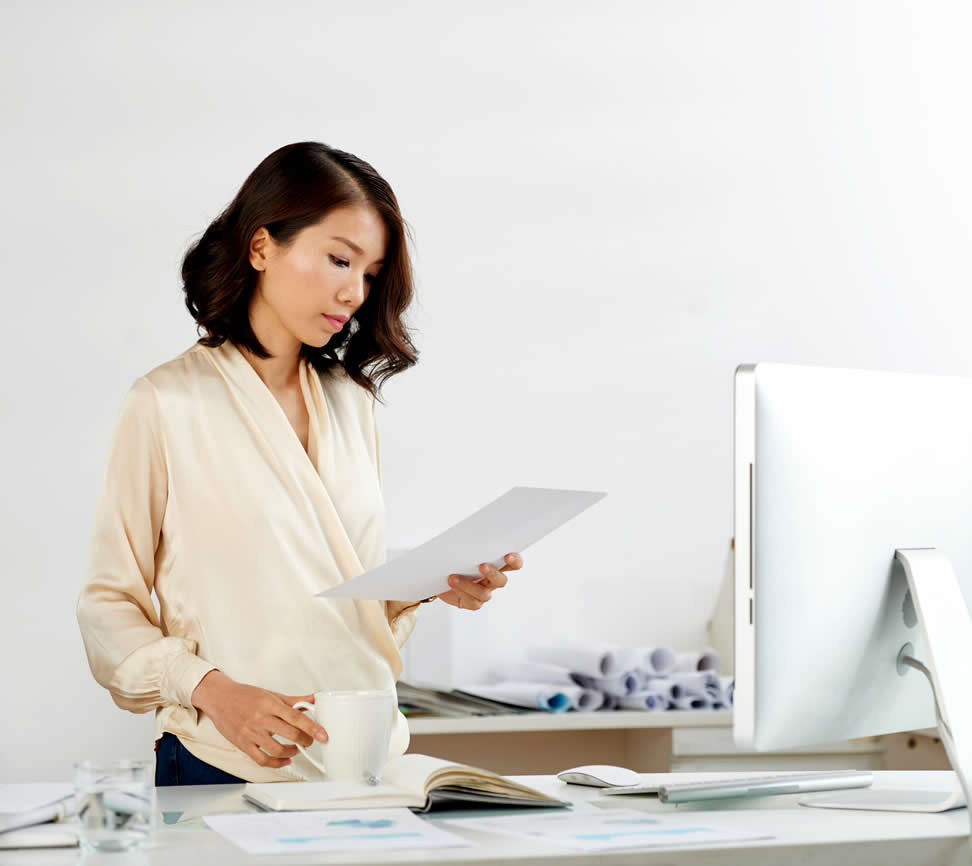 Young asian woman near computer showing singletasking as one of success habits
