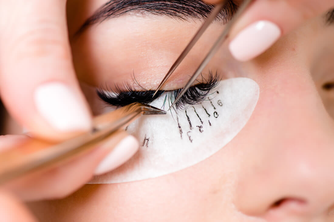 Woman getting eyelash extensions close up