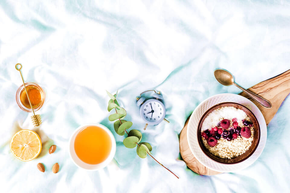 Fruits, nuts, oatmeals and a clock as an ilustration of intermittent fasting