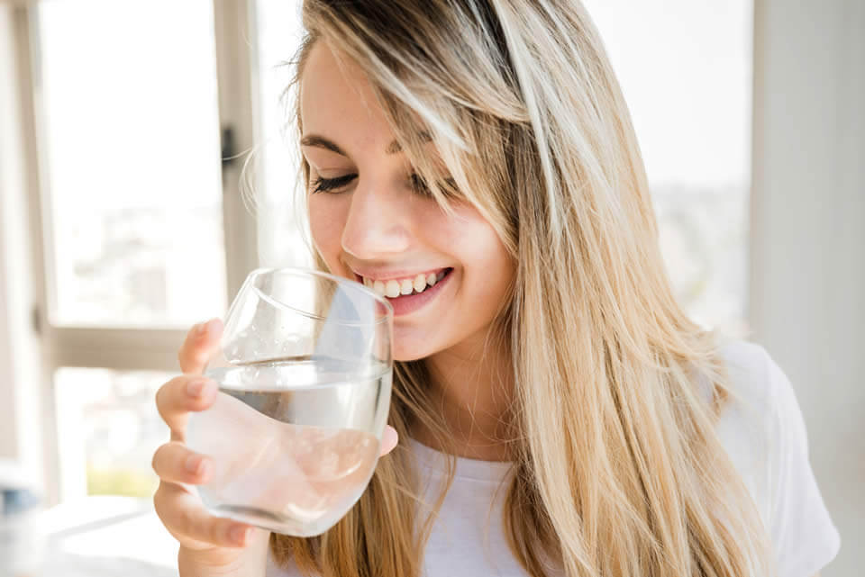 Young girl practicing her beauty habit of drinking water