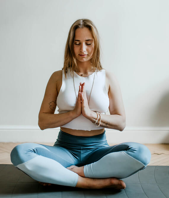 young person meditating on a mat