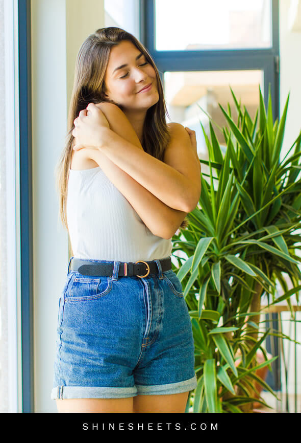woman practicing emotional self care by hugging herself at home