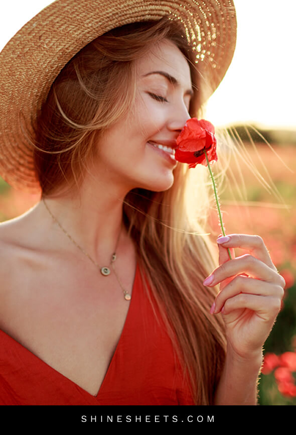 blonde woman practicing emotional self care by smelling flowers