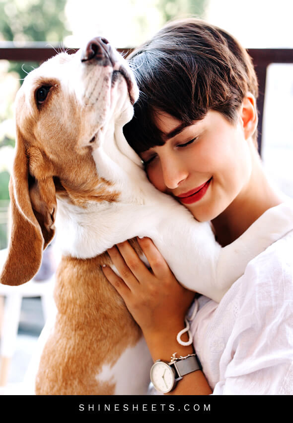 happy woman smiling hugging her dog