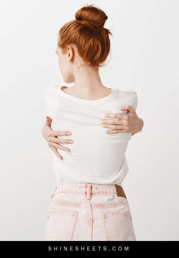 rear-view redhead woman hugging herself
