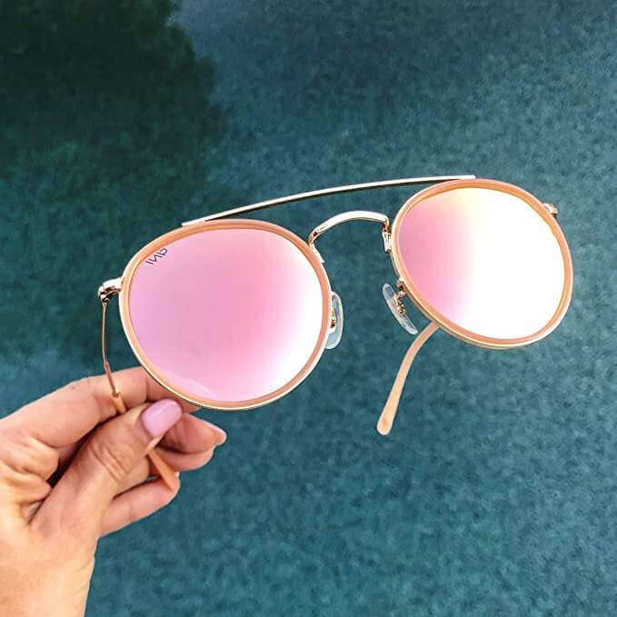 Woman with pink nails hols pink sunglasses
