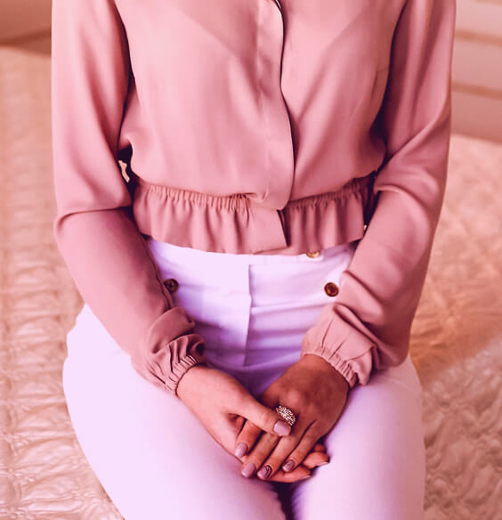 woman in pretty ruffled blush blouse showing her dressing sense