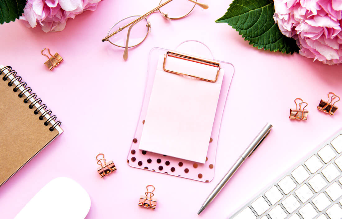 Planners, flowers and glasses on pink table as tools to practice self love