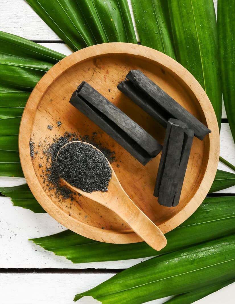 activated charcoal crushed on bamboo table as teeth whitening home remedies