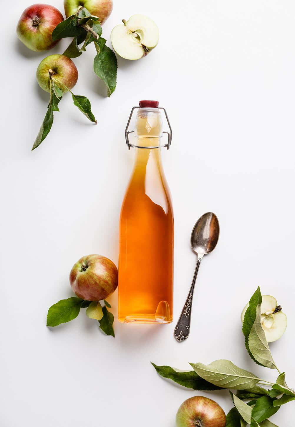 apple cider vinegar and apples on table as teeth whitening home remedies