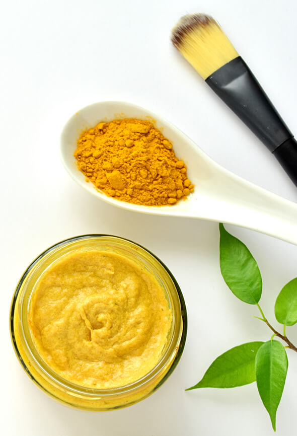 homemade turmeric face pack and a brush on the table