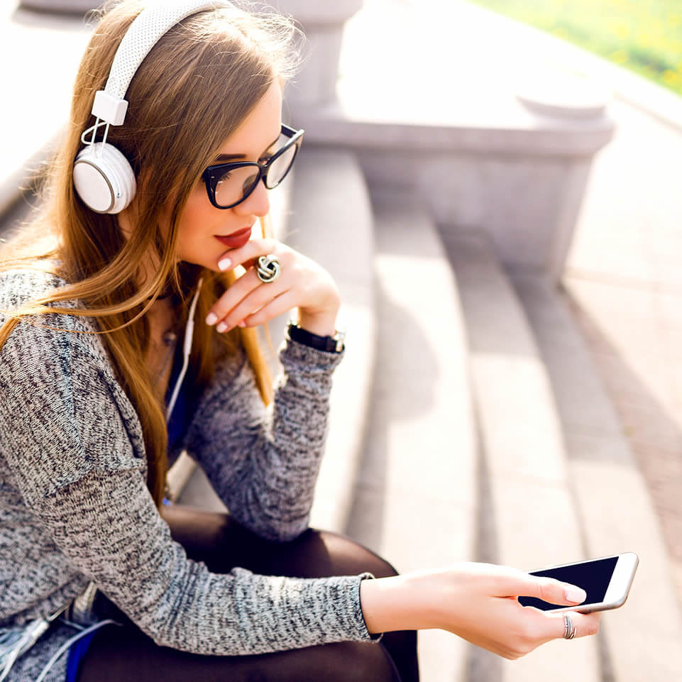 Woman with headphones shows how to make someone love you with phone messages