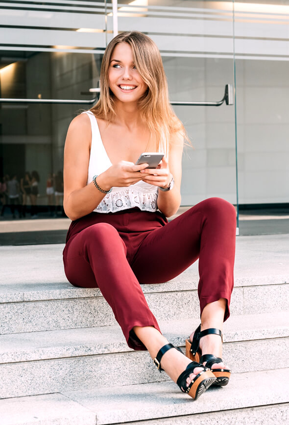 optimistic woman sitting outside and laughing