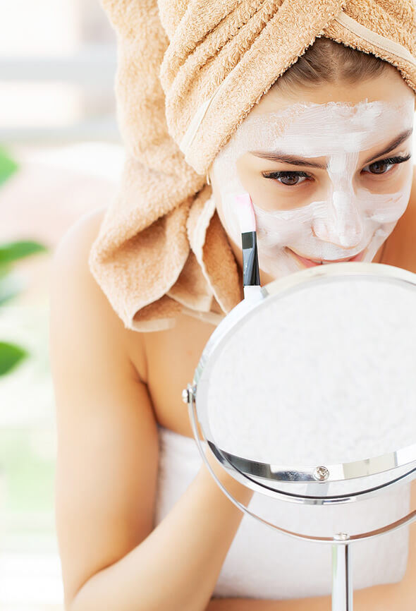 woman applying face pack on her face