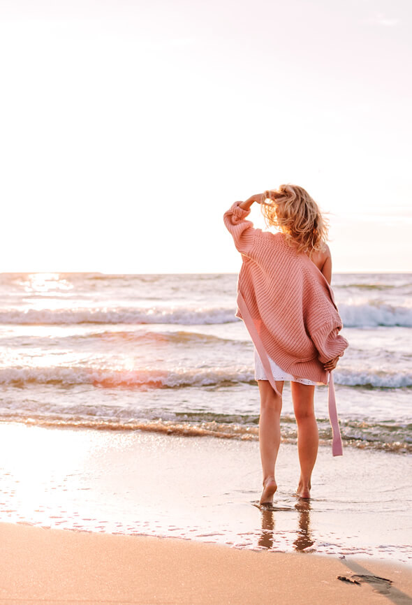 woman walking by the sea to feel better