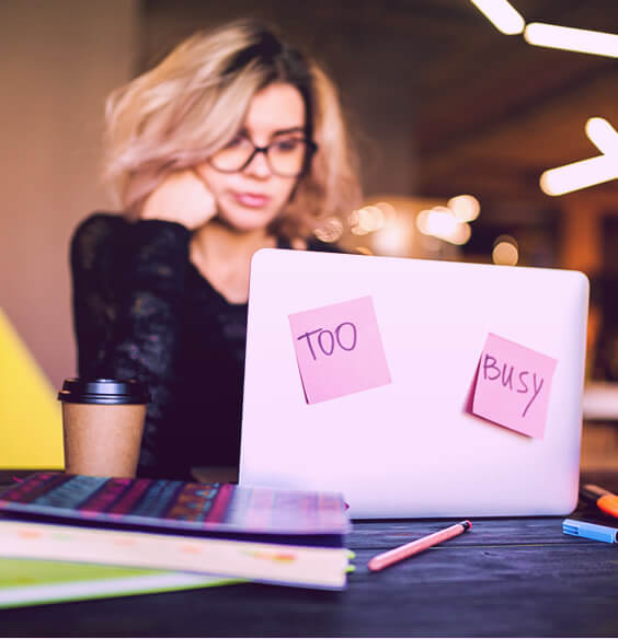 woman with a laptop trying to deal with her work overload