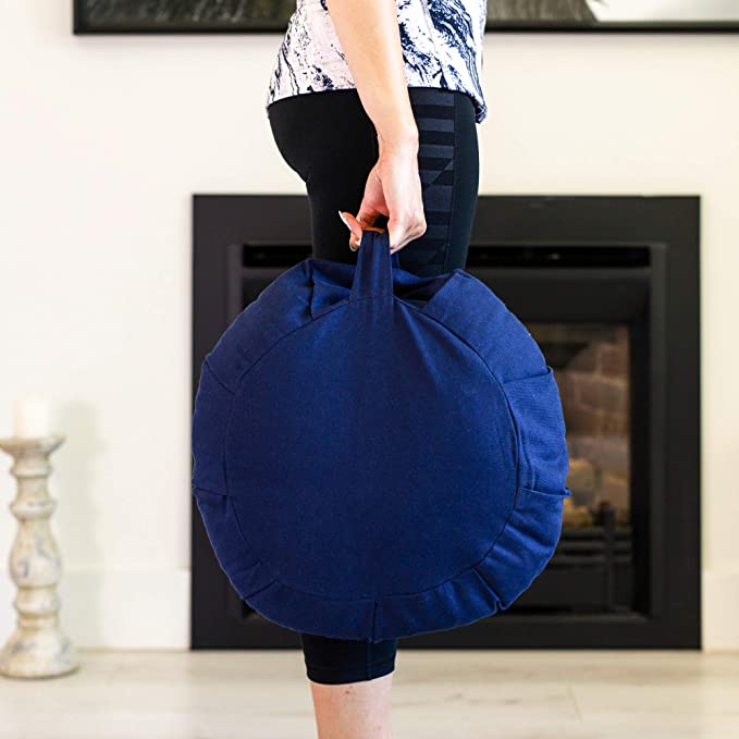 Woman carrying a meditation cushion in her hand