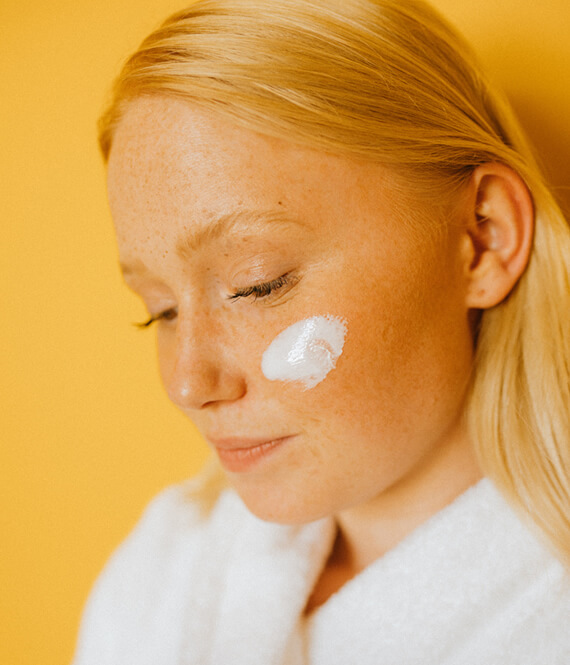 pretty woman with skincare product on her face