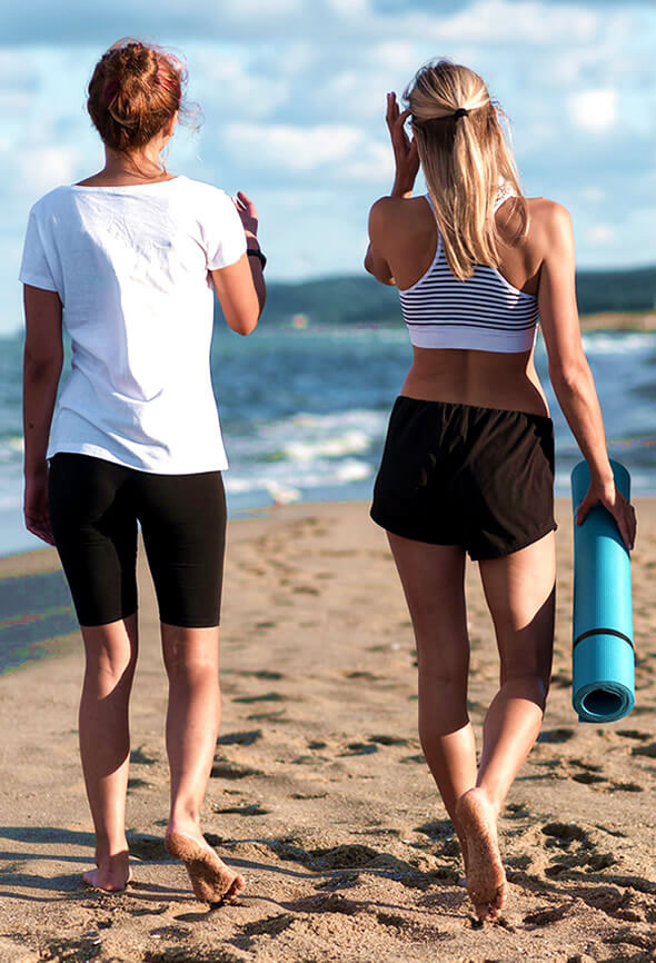 two women on the beach doing a walking challenge