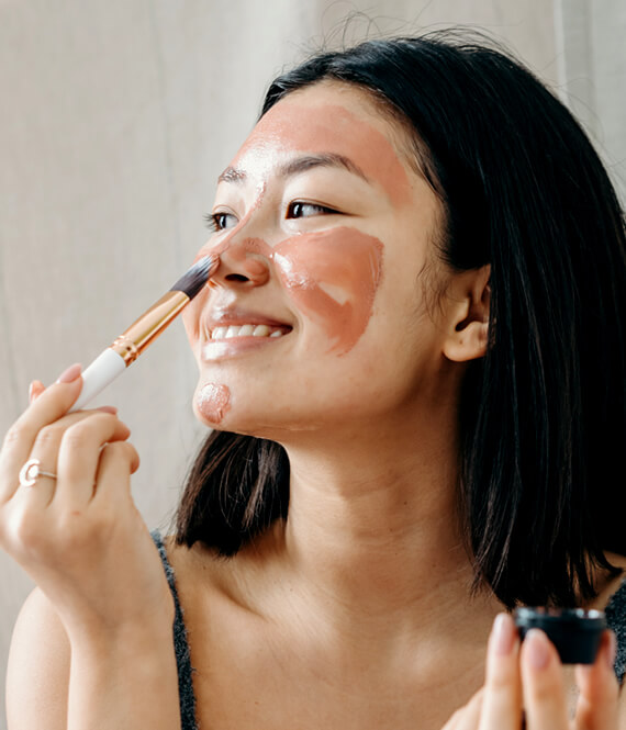 woman applying face mask as one of her beauty habits