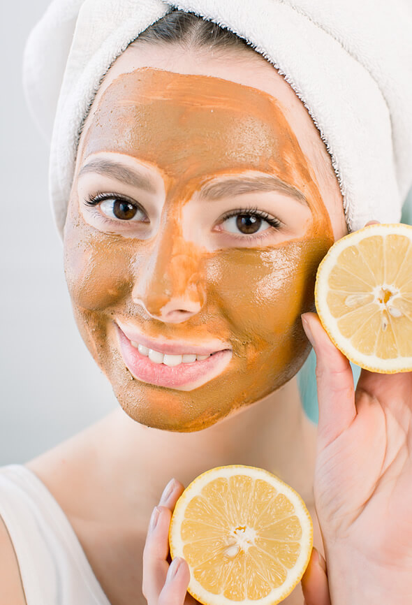 young woman using lemon pumpkin enzyme peel on her face