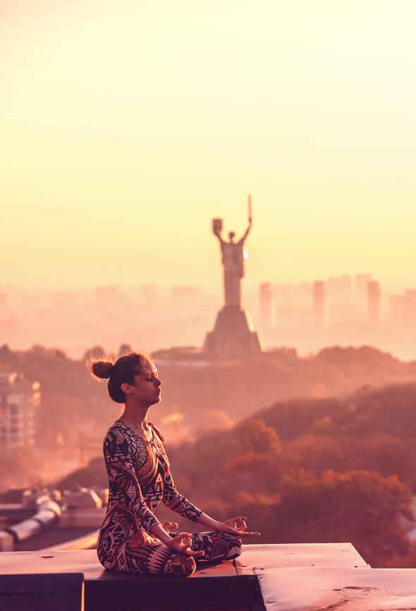 woman meditating on the top of the roof