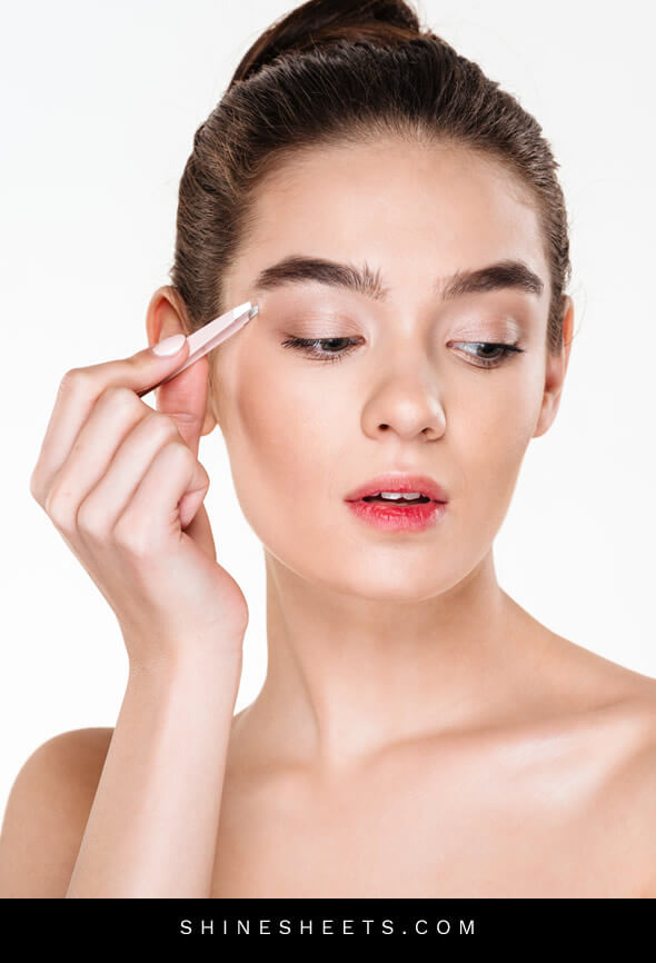 woman performing eyebrow plucking as part of her beauty habits