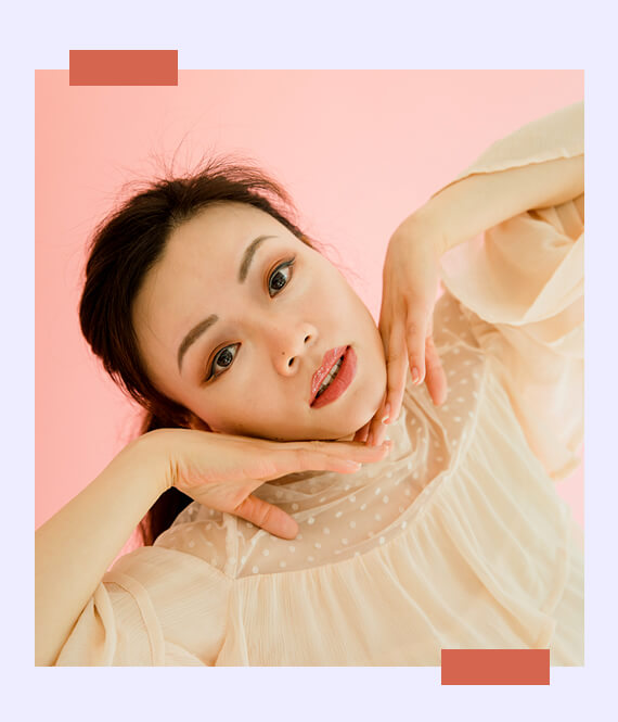 asian woman performing face yoga moves for less wrinkles