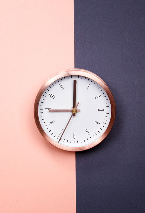 rose gold clock on pink and grey background