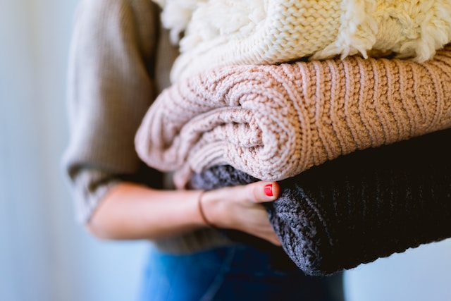 woman putting away laundry, sweaters