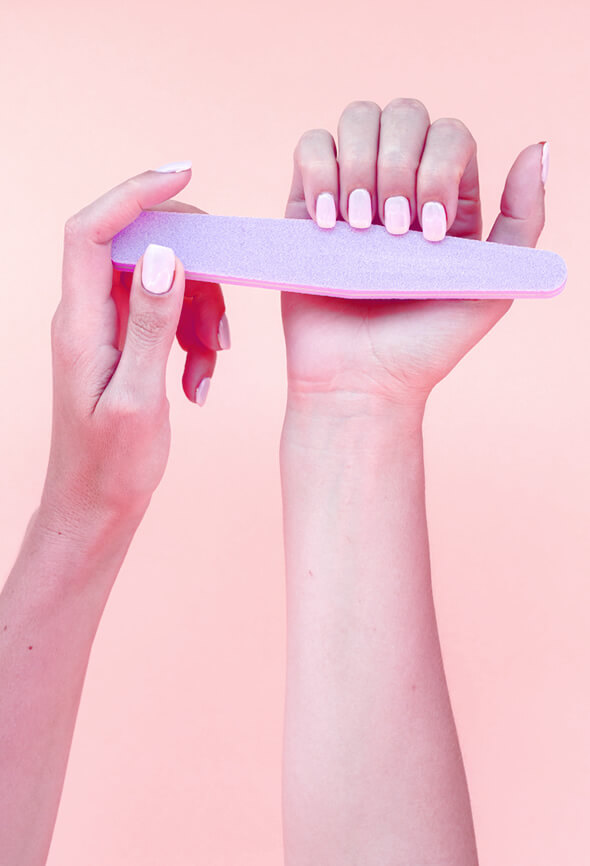 woman filing her painted nails