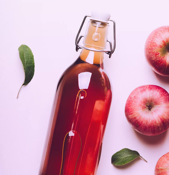 apple cider vinegar for hair rinse and apples on the table