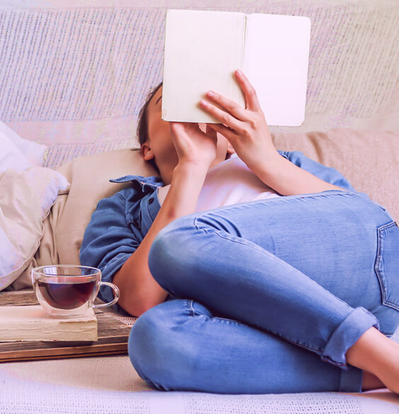 woman laying on the bed and writing in a journal