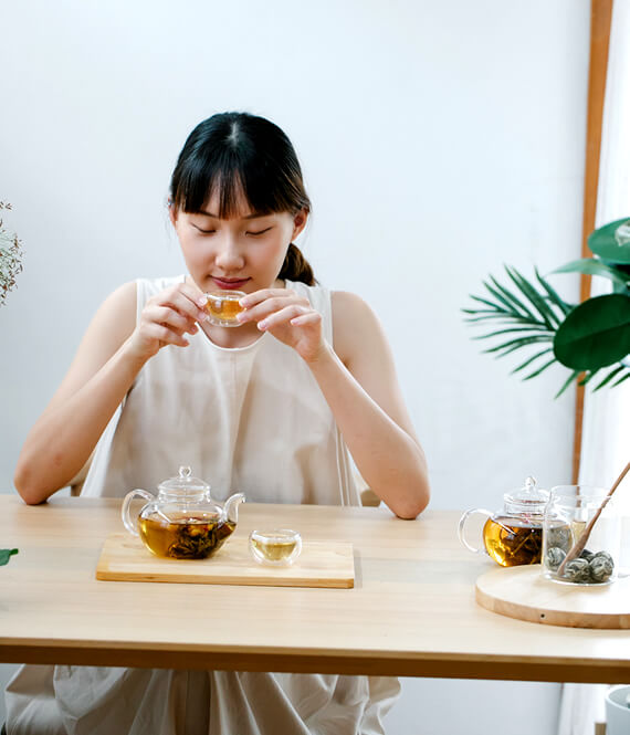asian woman drinking tea to manage stress and anxiety naturally